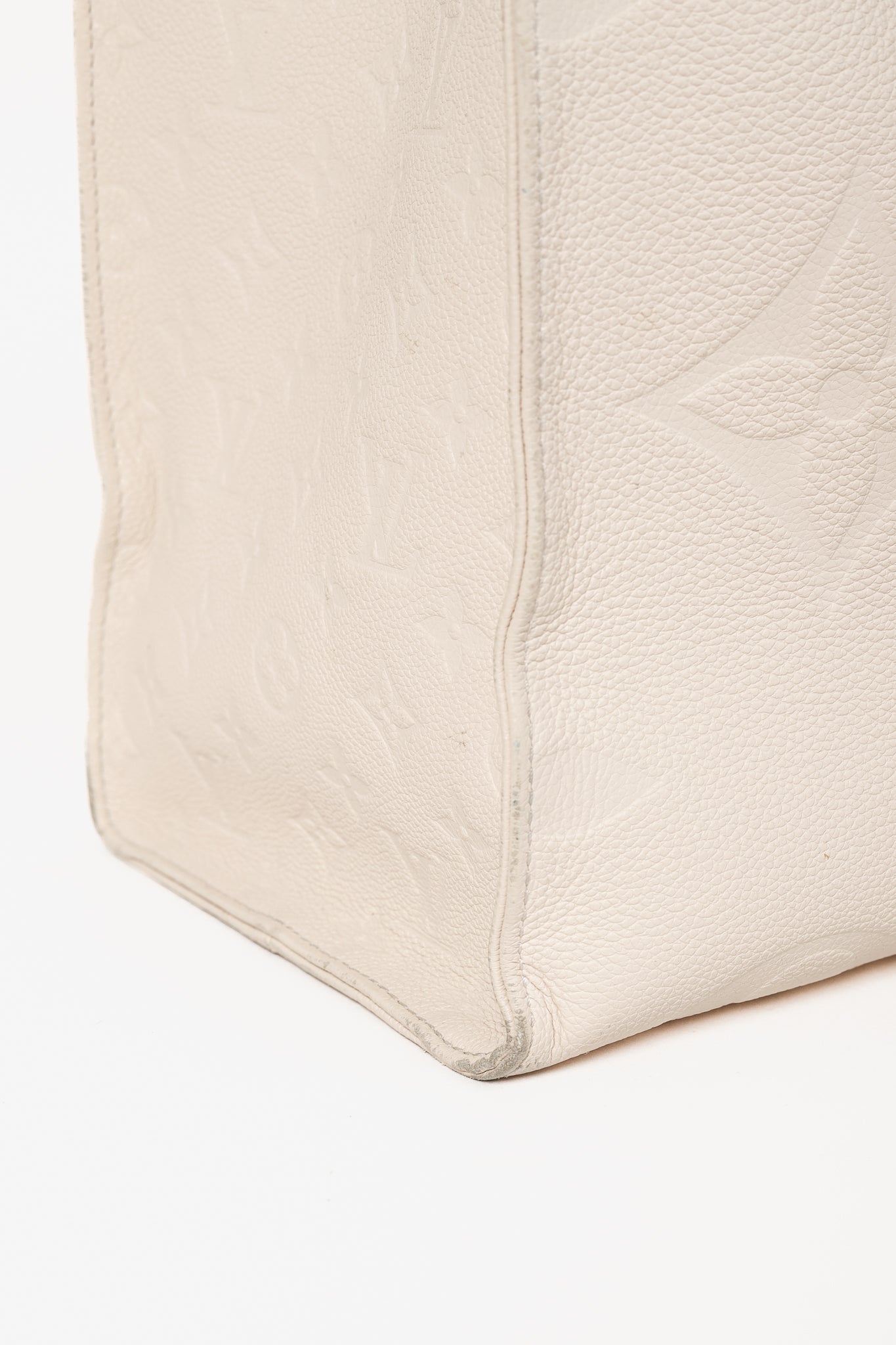 OnTheGo GM Creme Empreinte Monogram Leather Tote Bag