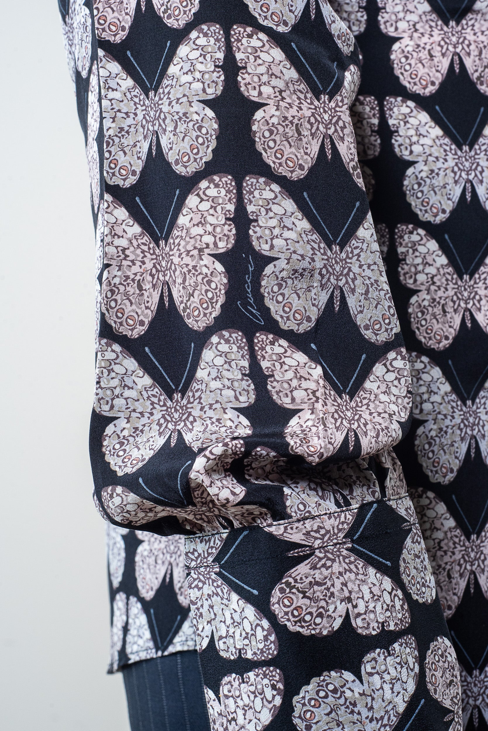 Close-up of butterfly print detail on Gucci silk shirt