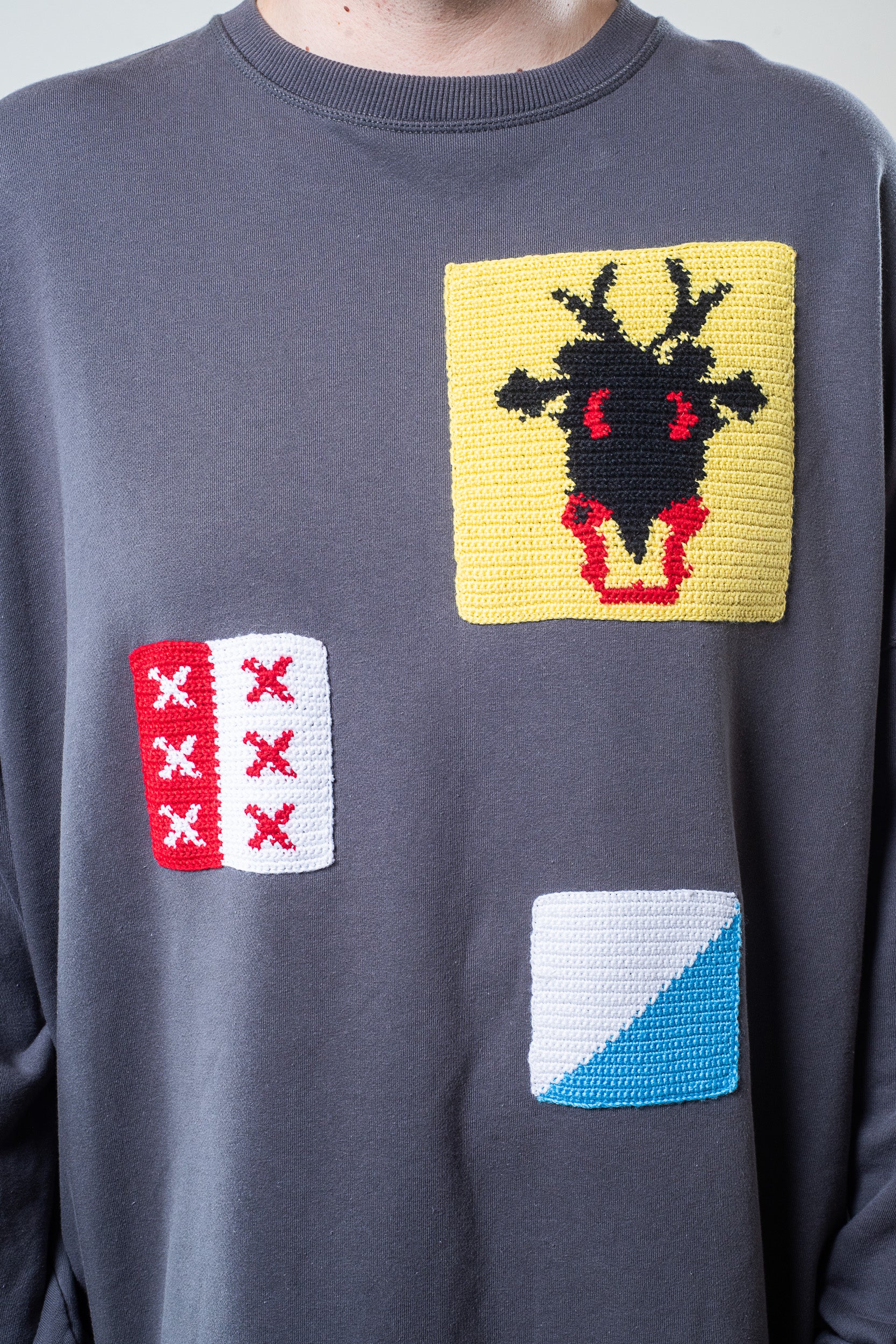 Close-up of patch details on J.W. Anderson cotton and wool sweater