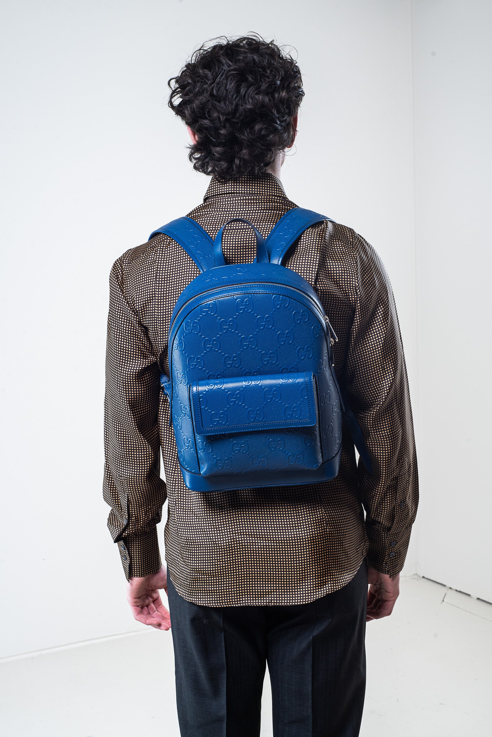 Model wearing Gucci silk patterned shirt with backpack – back view