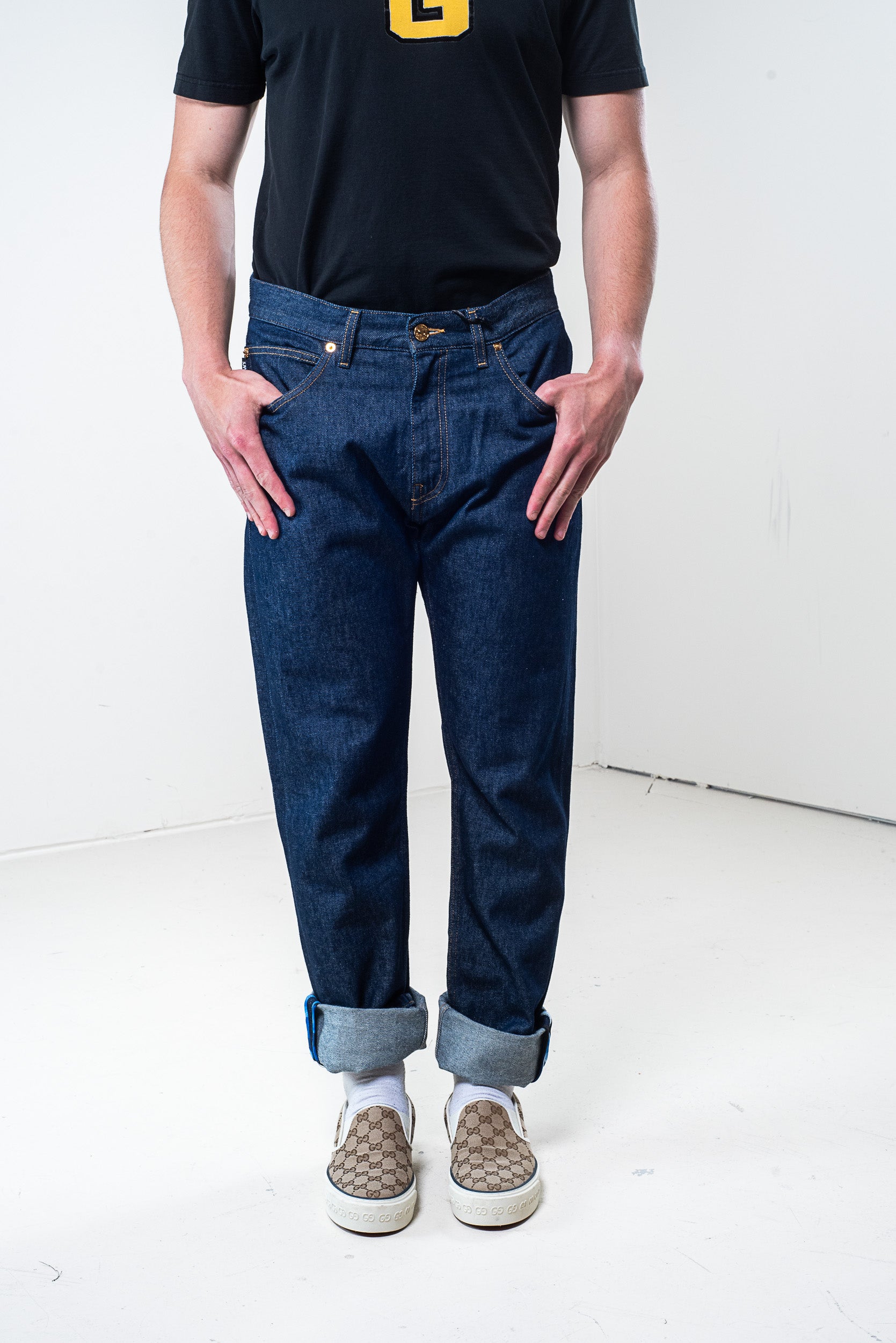 Full front view of Versace dark denim pants with logo stitching