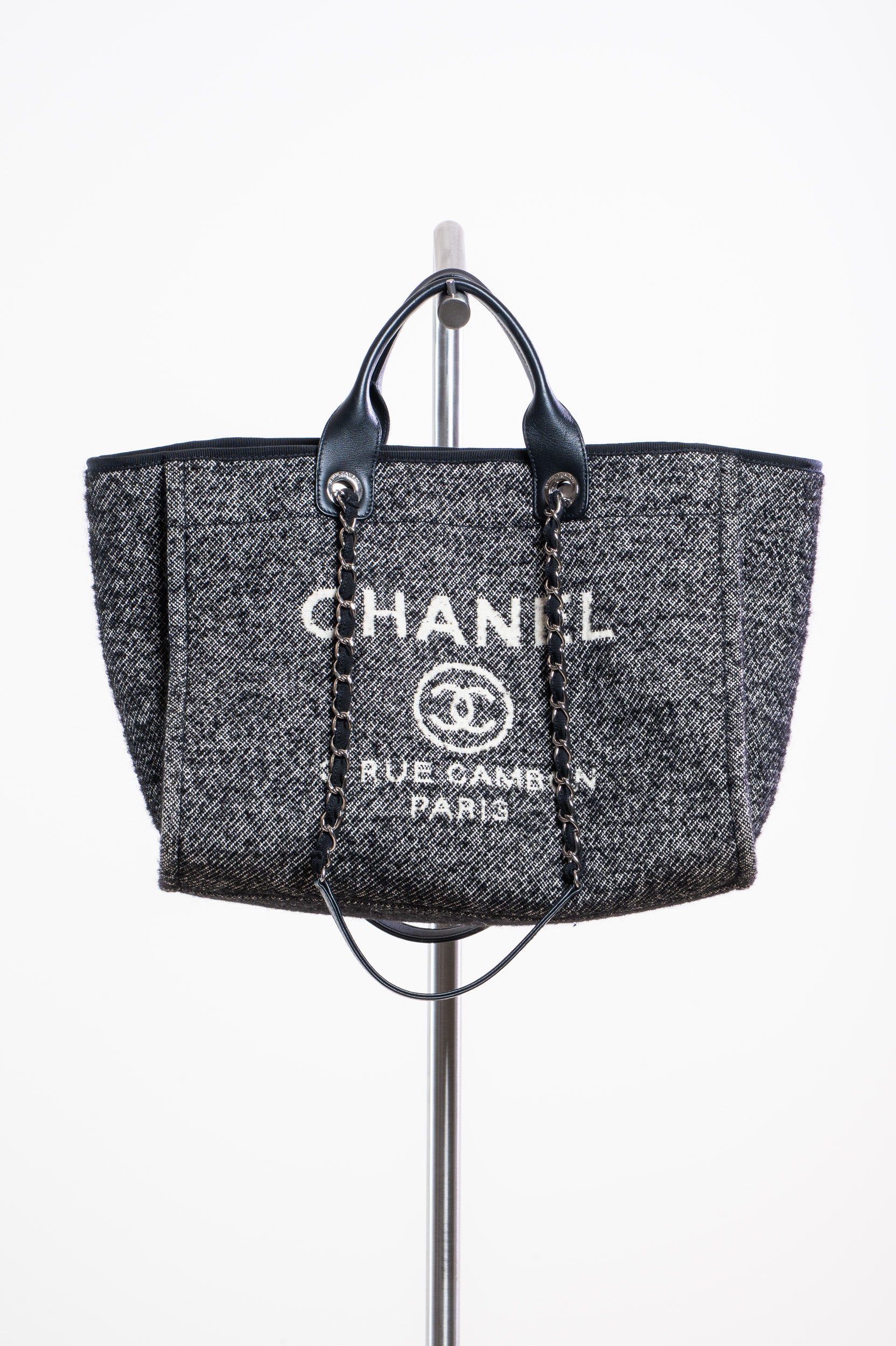 Chanel handbag displayed on a stand with a white background