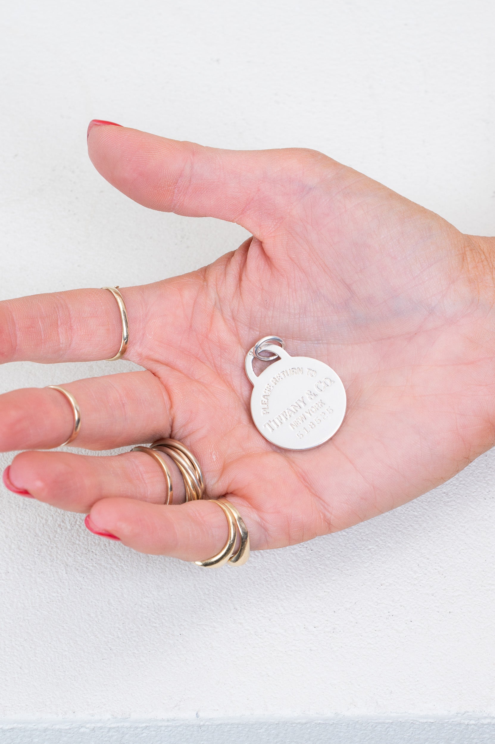 Tiffany & Co. Return to Tiffany Round Tag Circle Charm resting in palm