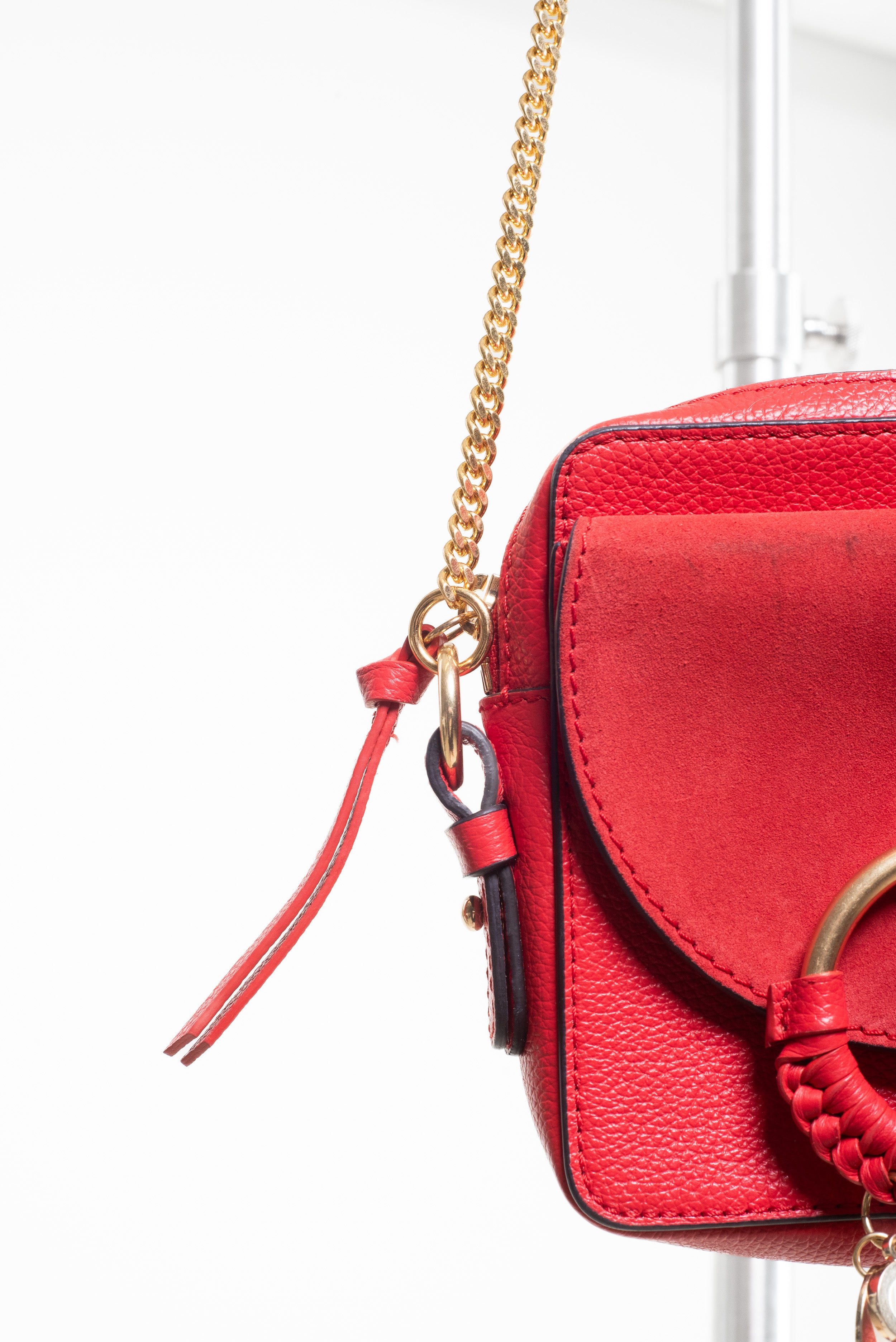 Detailed view of the strap connection and gold-tone hardware on the See by Chloé Small Red Joan Crossbody