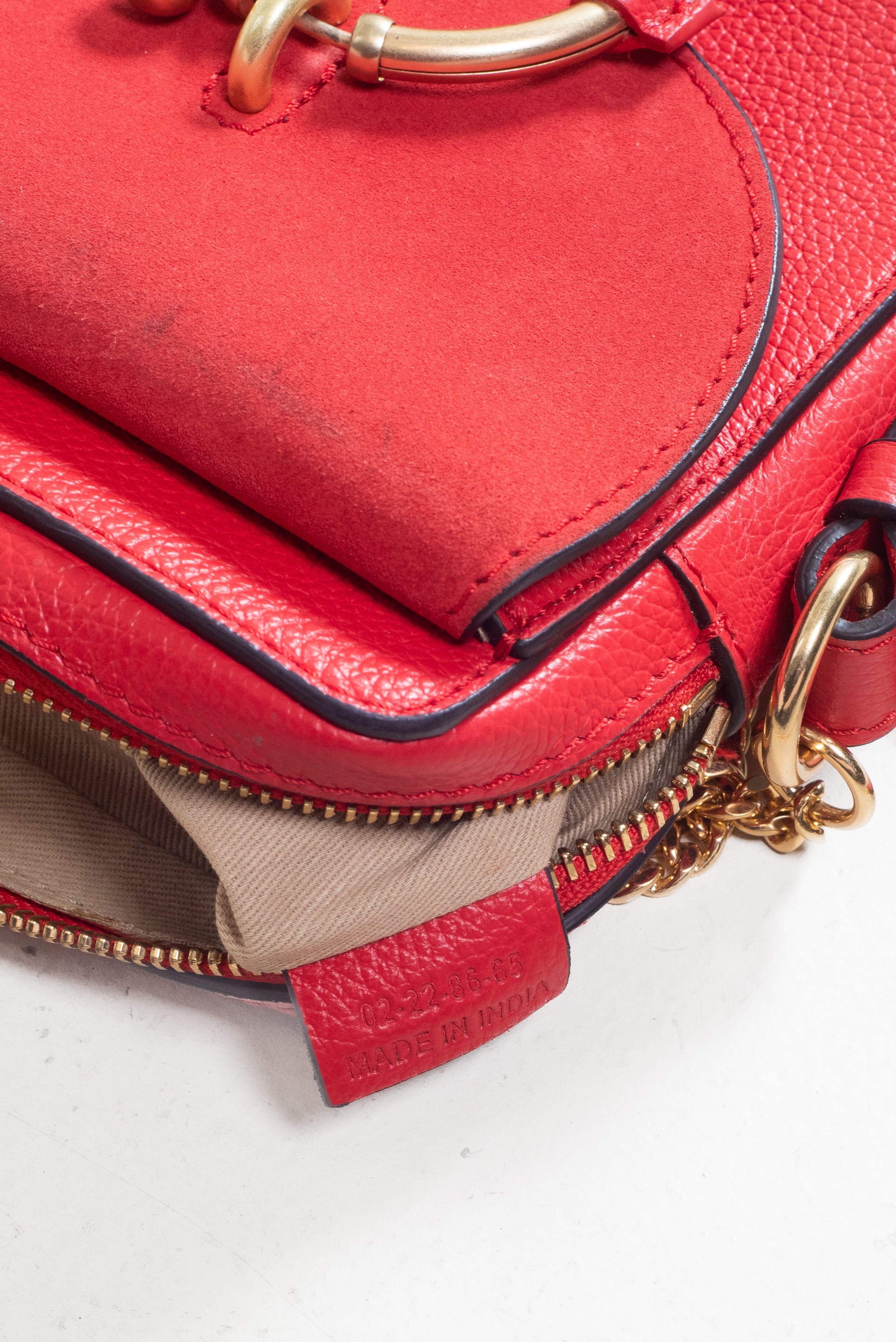 Close-up of red suede flap detail on See by Chloé Small Red Joan Crossbody