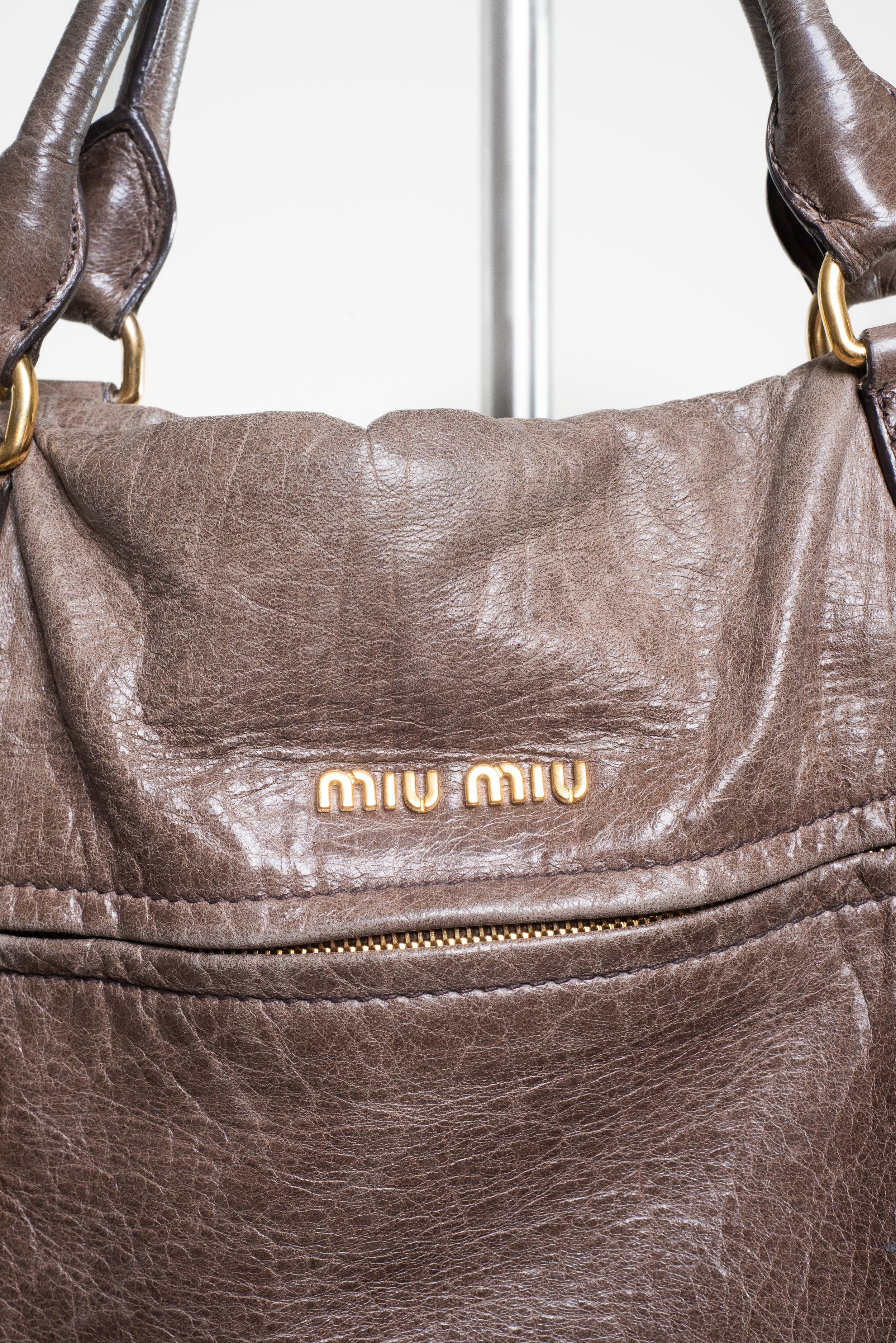 Close-up front view of Miu Miu Brown Leather Gold Lock Bag 