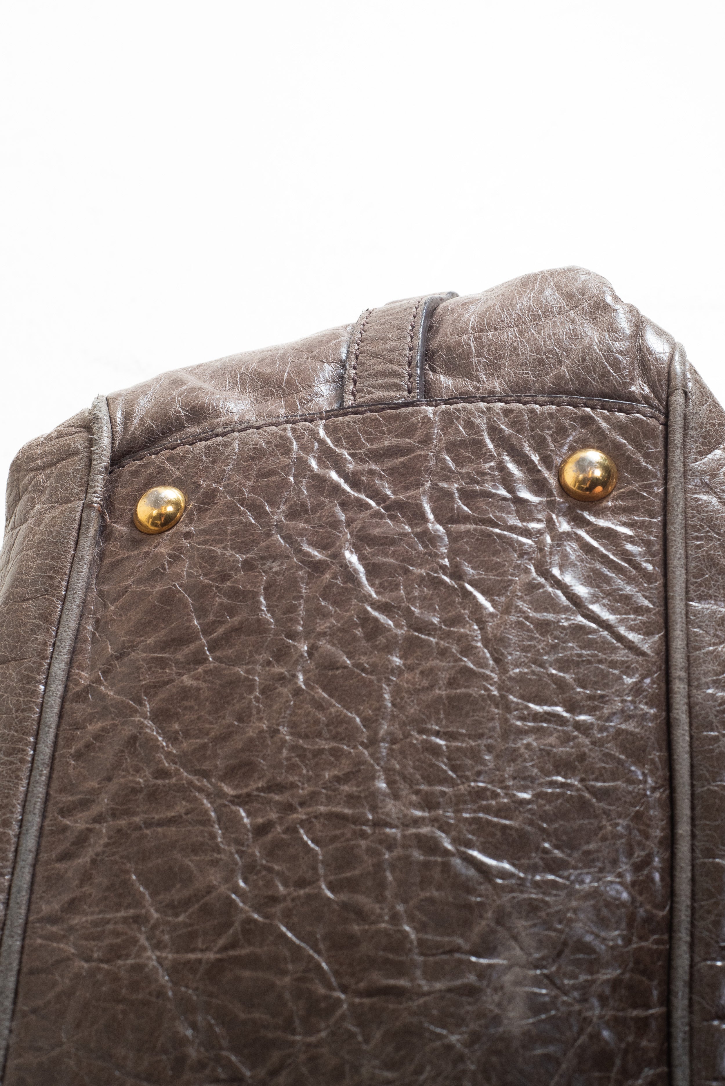 Detailed view of the bottom base and leather texture on the Miu Miu Brown Leather Gold Lock Bag