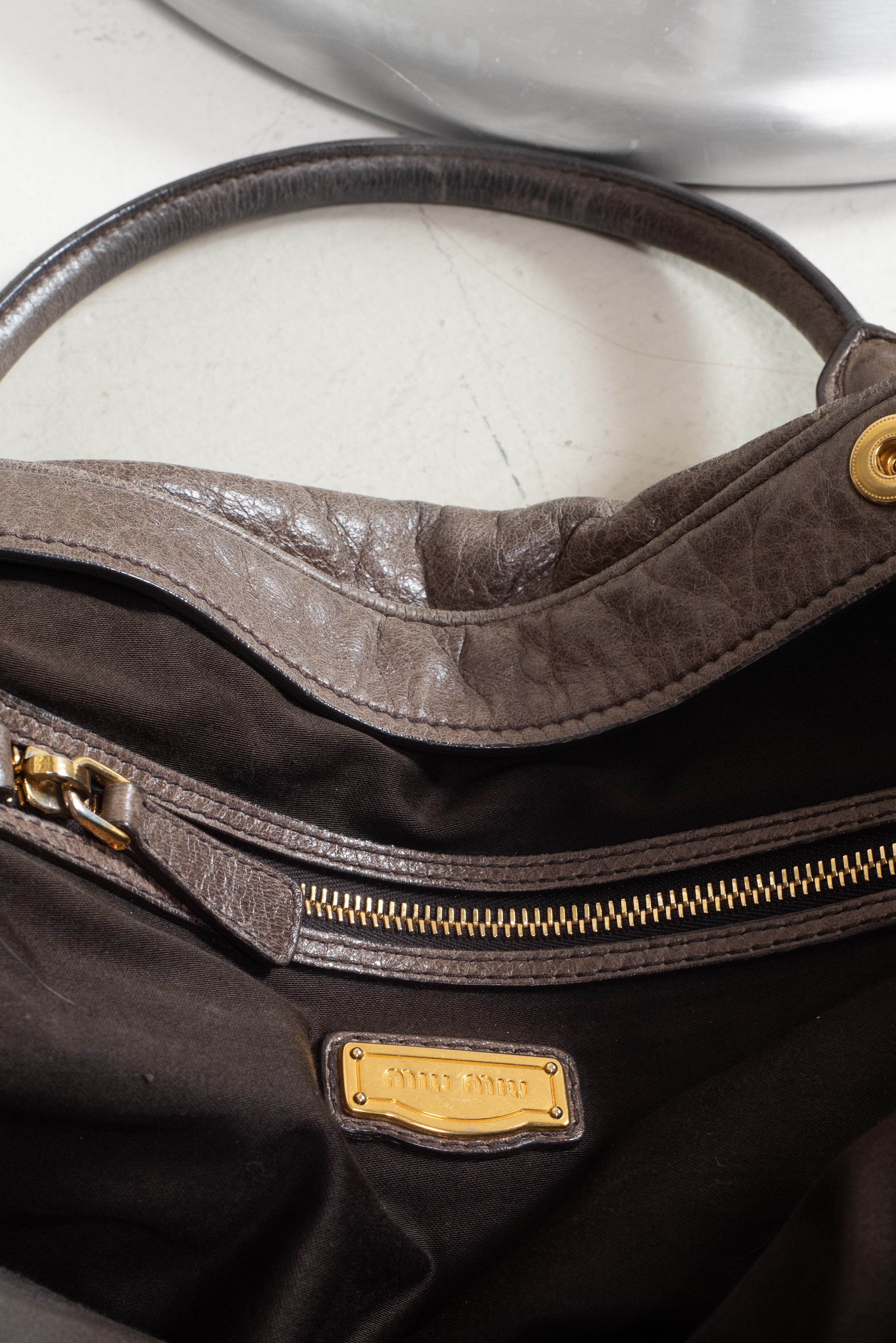 Open top view of Miu Miu Brown Leather Gold Lock Bag