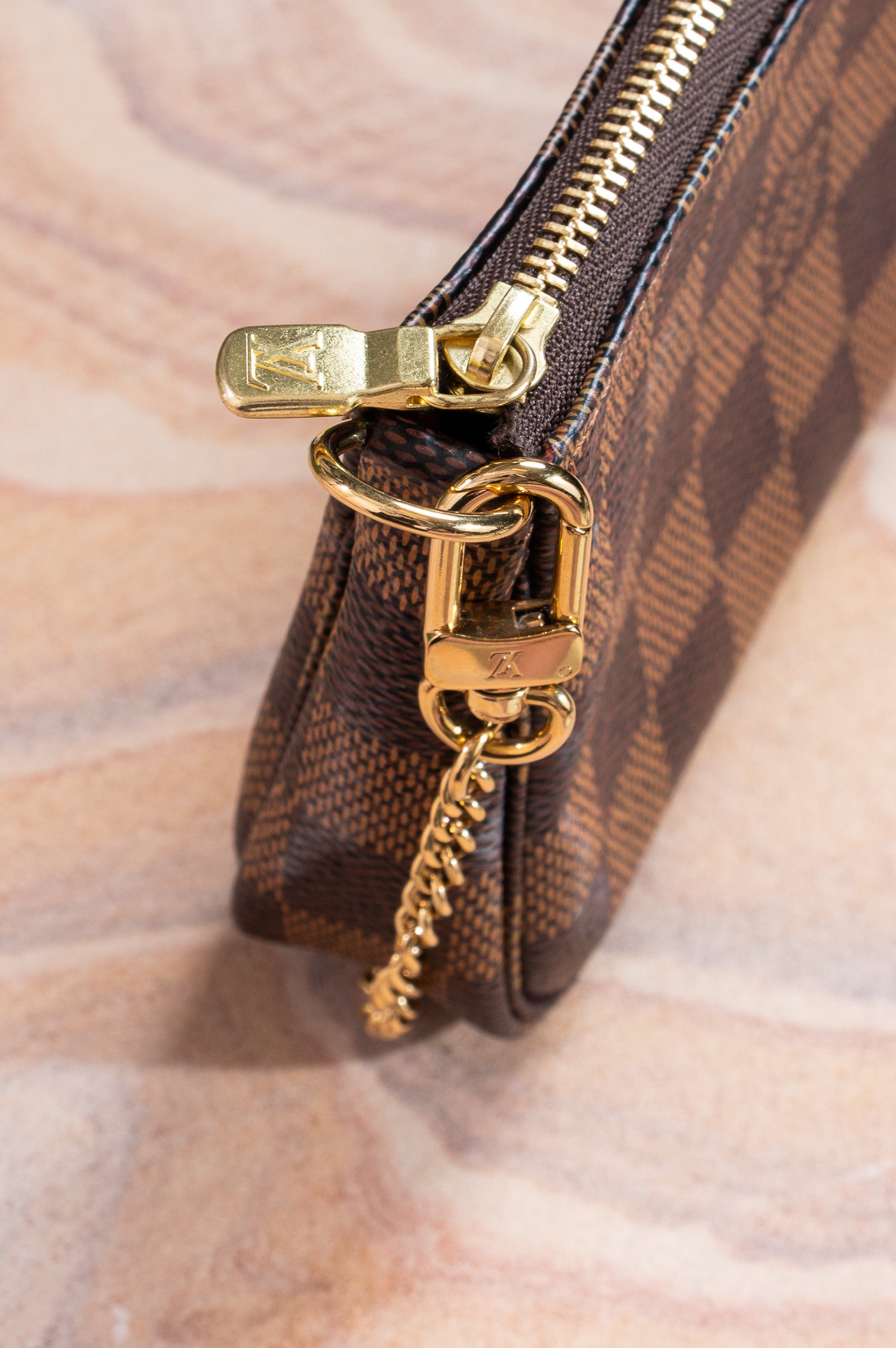 Close-up view of Louis Vuitton Damier Ebene Mini Pochette Accessoires 